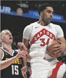  ?? AP PHOTO/DAVID ZALUBOWSKI ?? Toronto Raptors center Jontay Porter (right) pulls in a rebound as Denver Nuggets center Nikola Jokic (left)defends in the first half of an NBA basketball game on March 11 in Denver.