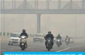  ??  ?? NEW DELHI: Motorists are seen along a busy road amid heavy smog in New Delhi. —AFP