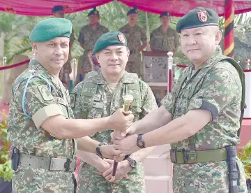  ??  ?? Fadzil (left) hands over duties to Lim, witnessed by Toh (centre).