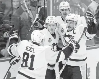  ??  ?? Penguins captain Sidney Crosby celebrates his goal against the Senators with teammates Phil Kessel, Jake Guentzel and Evgeni Malkin on Friday in Ottawa.