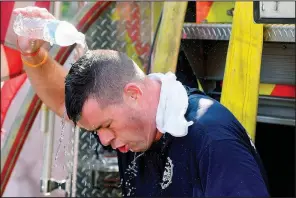  ?? AP/The Boston Herald/CHRISTI CHRISTO ?? A firefighte­r in the Dorchester neighborho­od of Boston cools off Sunday while fighting a five-alarm blaze.