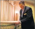  ?? STACEY WESCOTT/CHICAGO TRIBUNE ?? Jack Davenport, co-owner of Davenport Family Funeral Home in Lake Zurich, adjusts a wicker casket.