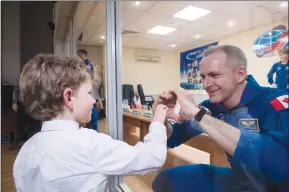  ?? Associated Press photo ?? Expedition 58 Flight Engineer David Saint-Jacques of the Canadian Space Agency (CSA), who is in quarantine, makes a heart with his hands for his son at the conclusion of a press conference Sunday at the Cosmonaut Hotel in Baikonur, Kazakhstan. Launch of the Soyuz rocket is scheduled for today.