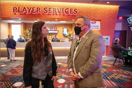  ?? (Photo Courtesy of Oaklawn/Ben Gibson) ?? Ray Lunsford talks with Holly Harvey, a game room attendant, at Oaklawn. For Lunsford, director of casino operations, working nights is a means to an end … so he takes the sacrifices it calls for in stride.