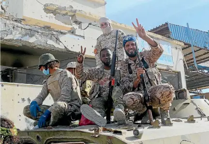  ?? PHOTOS: REUTERS ?? Fighters with Libyan forces allied with the United Nations-backed government celebrate after they finished clearing Ghiza Bahriya, the final district of the former Islamic State stronghold of Sirte.