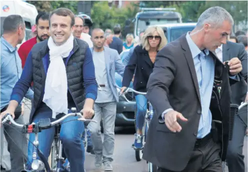  ??  ?? Emmanuel Macron opušteno je ulicama Pariza vozio bicikl u društvu supruge Brigitte