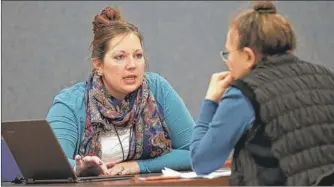  ??  ?? Amanda Deardorff (eft), a health enrollment navigator with Open Door Health Solutions, helps Valerie Kazer through the process of signing up for coverage under the Affordable Care Act in Muncie.