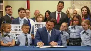  ?? (AP/Tampa Bay Times/Douglas R. Clifford) ?? Florida Gov. Ron DeSantis signs the Parental Rights in Education bill Monday at Classical Preparator­y School in Shady Hills, Fla.