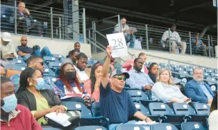  ?? TED GLANZER/HARTFORD COURANT ?? Felipe Malero bids on a property at Dunkin’ Donuts Park in Hartford on Thursday.