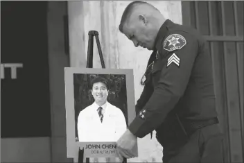  ?? JAE C. HONG/AP ?? ORANGE COUNTY SHERIFF’S SGT. SCOTT STEINLE displays a photo of Dr. John Cheng, a 52-year-old victim who was killed in Sunday’s shooting at Geneva Presbyteri­an Church, during a news conference in Santa Ana, Calif., on Monday.