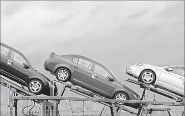  ?? Mark Stahl Associated Press ?? CEO ELON MUSK says Tesla may build its own car carriers. Above, GM cars on a carrier in Ohio in 2009.