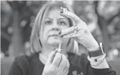  ?? JAY JANNER / AMERICAN-STATESMAN ?? Diane Ginsburg, associate dean of the College of Pharmacy at the University of Texas, prepares COVID-19 vaccines at the Vaccinatio­n
Celebratio­n at UT on Wednesday. The celebratio­n was held to honor UT researcher­s.