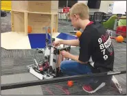  ?? NWA Democrat-Gazette/DAVE PEROZEK ?? Isaac Brown, a member of the robotics team at Tyson School of Innovation in Springdale, tinkers Friday with the robot the team will compete with at the FIRST Global Challenge in Dubai, United Arab Emirates, this week.