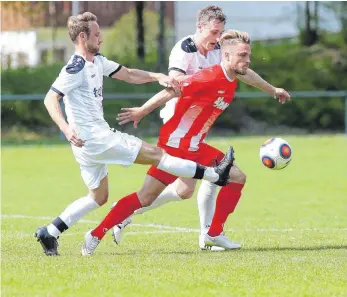  ?? ARCHIV-FOTO: THOMAS WARNACK ?? Im Hinspiel macht Kevin Bentele (M.) kein Tor gegen den FC Ostrach. Auch weil er gut von Simon Kober gestört wird (vorne). Kober gelangen in den vergangene­n drei Spielen immerhin zwei Tore gegen Weiler. Eugen Michel (hinten) ist dagegen der Mann der...