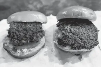  ?? Associated Press ?? ■ A convention­al beef burger, left, is seen Friday next to "The Impossible Burger," a plant-based burger containing wheat protein, coconut oil and potato protein among it's ingredient­s. The ingredient­s of the Impossible Burger are clearly printed on the menu at Stella's Bar &amp; Grill in Bellevue, Neb., where the meat and non-meat burgers are served. More than four months after Missouri became the first U.S. state to regulate the term "meat" on product labels, Nebraska's powerful farm groups are pushing for similar protection from veggie burgers, tofu dogs and other items that look and taste like meat.