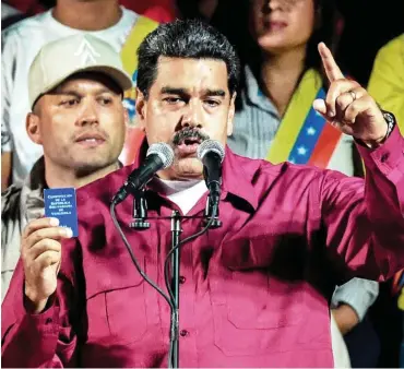  ?? Foto: AFP/Juan Barreto ?? Wahlsieger Maduro am Sonntag mit der Verfassung Venezuelas in der Hand