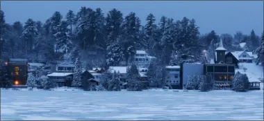  ?? MIKE GROLL—ASSOCIATED PRESS ?? In this Thursday, Dec. 11, 2014file photo, night falls over the homes and condominiu­ms on the banks of Mirror Lake in Lake Placid, N.Y. The surge in the number of short-term rentals in this Adirondack Mountain resort is alarming local residents who fear it is changing the character of the village.