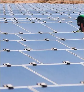 ??  ?? An O&M field technician walks through a photovolta­ic array at the Albuquerqu­e Solar Energy Center at Reeves Generating Station in 2011.