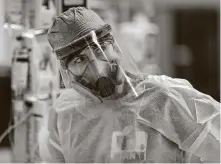  ?? Bob Owen / Staff photograph­er ?? Evelyn Menking, wearing her N-100 mask and a shield, prepares to enter a patient’s room in the Northeast Baptist Hospital COVID-19 intensive care unit May 19.