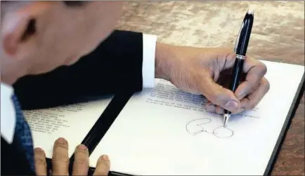  ?? PICTURE: THE CONVERSATI­ON ?? Former US president Barack Obama signs documents at his desk – with his left hand.