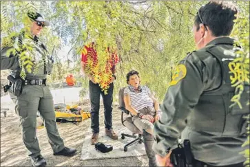  ?? Maria Alejandra Cardona Los Angeles Times ?? SHER STUCKMAN, center, speaks to sheriff ’s deputies clearing an encampment in Anaheim, along the Santa Ana River. Stuckman says she is on a waiting list for housing, but she wants to stay near the river.