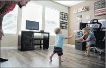  ??  ?? Travis Matheson, left, watches as his son, Wyatt, 1, walks over to his daughter, Lylah, 4, on Sunday in their home in Las Vegas.