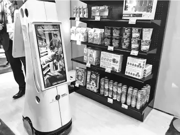  ??  ?? Lowe’s hardware stores use robots to restock shelves and guide customers to products.