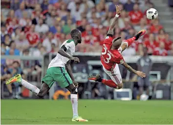  ?? — AP ?? Bayern Munich’s Arturo Vidal attempts an acrobatic kick as Ludovic Lamine Sane of Werder Bremen tries to catch up in their German league match at the Allianz Arena stadium in Munich, Germany, on Friday. Bayern won 6- 0.