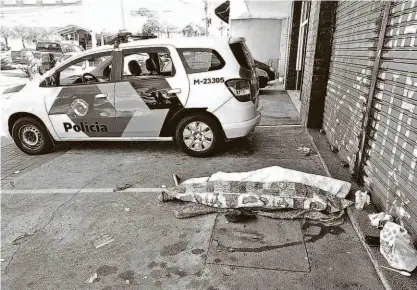  ?? Rivaldo Gomes/folhapress ?? Carro da polícia ao lado do corpo de Marciano da Silva Correia, 34 anos, em marquise de loja na avenida do Rio Pequeno, zona oeste da capital; outro morador de rua foi achado morto no Parque Dom Pedro, no centro