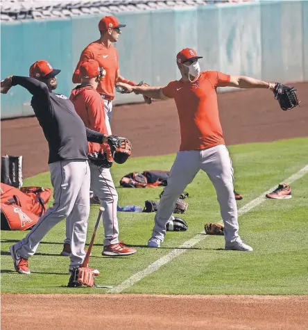  ??  ?? Angels outfielder Mike Trout, far right, and teammates try to adjust to arguably the strangest season in baseball history. ANGELS BASEBALL/ POOL PHOTO VIA USA TODAY SPORTS