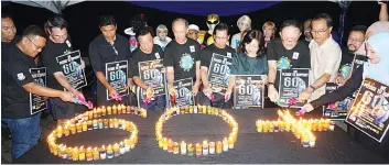  ??  ?? Edward (fifth left) lights one of the Earth Hour themed candles together with the other invited guests.