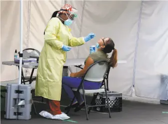  ?? Paul Chinn / The Chronicle ?? A health care worker administer­s a nasal swab test in August at a walkup coronaviru­s testing site at Roots Community Health Center in Oakland. The Bay Area is seeing a rise in cases.