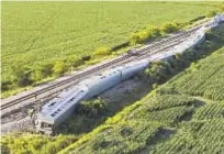  ?? ?? An Amtrak train lies derailed after it hit a truck at a crossing Monday near Mendon, Mo. Four people were killed.