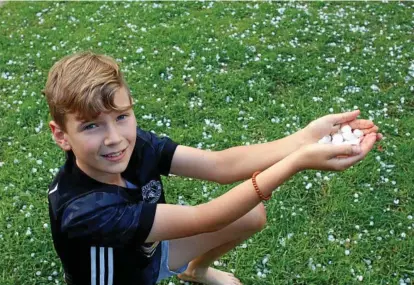  ??  ?? SPOT OF HAIL: Quinn Farmer collects hail after it fell in Rangeville last year.Photo: Kevin Farmer