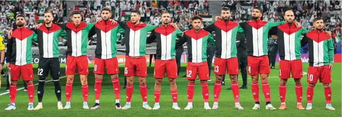  ?? GETTY IMAGES ?? Making a statement: Palestine players line up in the colours of their flag ahead of kick-off in Al Rayyan, Qatar yesterday