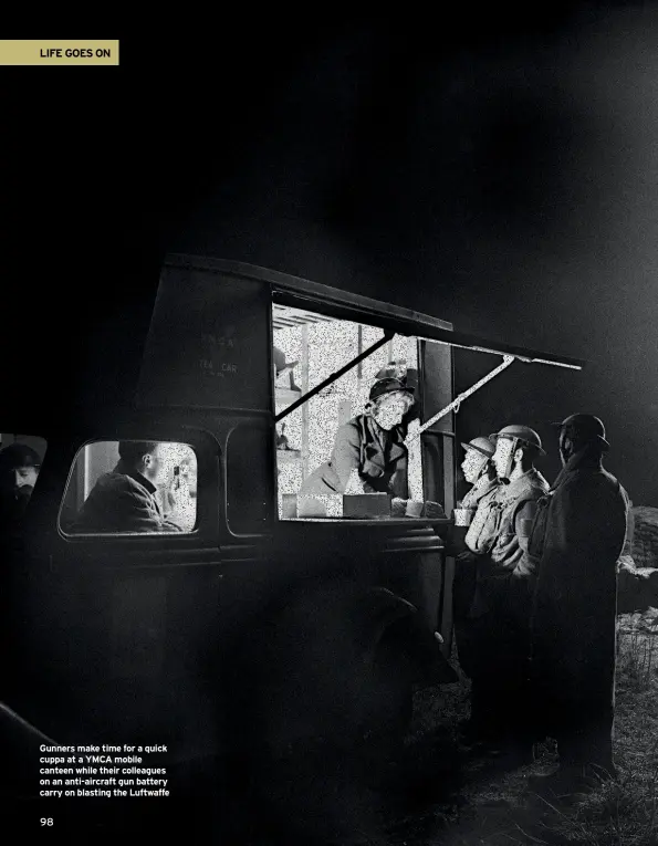  ??  ?? Gunners make time for a quick cuppa at a YMCA mobile canteen while their colleagues on an anti-aircraft gun battery carry on blasting the Luftwaffe