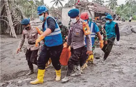  ?? EPA PIC ?? Rescuers carrying the body of a victim in an area affected by the eruption of Mount Semeru in Lumajang, east Java, yesterday.