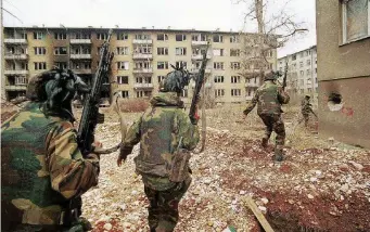  ??  ?? In Bosnia e in Campania Un soldato italiano nel 1996; a destra, la cassa di proiettili all’uranio impoverito fotografat­i a Pozzuoli (Napoli) nel 1994