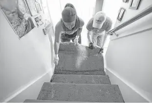  ?? James Nielsen / Houston Chronicle ?? Shira Patton removes flooded carpets from her grandmothe­r’s home Sunday with help from Foundry United Methodist Church member Rob Calbat.