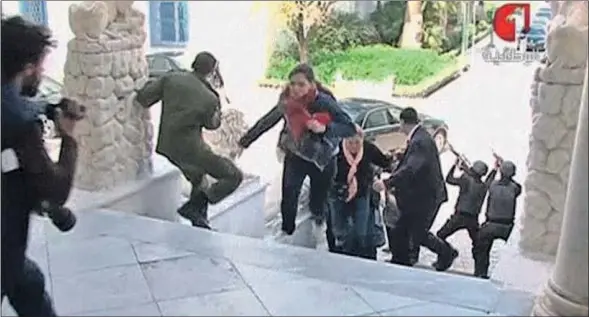  ?? TUNISIA TV / REUTERS ?? Terror. Unos turistas en el Museo del Bardo se ponen a cubierto de los disparos, protegidos por las fuerzas de élite de Túnez