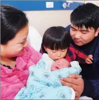  ?? WANG BIAO / FOR CHINA DAILY ?? A girl kisses her little brother while their parents look on at a hospital in Fuyang, Anhui province.