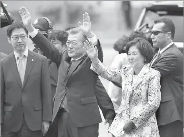  ?? Lee Jin-man Associated Press ?? PRESIDENT Moon Jae-in and First Lady Kim Jung-sook greet supporters at the Blue House, South Korea’s presidenti­al complex, in Seoul. “I will strive to get rid of authoritar­ian practices in the presidency,” he said.