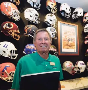  ?? John Raoux / Associated Press ?? Steve Spurrier stands in front of a display of helmets of teams that he previously played for or coached at his new restaurant, the Gridiron Grill, on June 17 in Gainesvill­e, Fla. The restaurant doubles as Spurrier's personal museum.