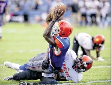  ??  ?? Dennis Hubbard lunges over John I. Leonard’s Jaquan Gray to complete an 18-yard touchdown run that gave Gardens a 7-0 lead. The Gators later lost a fumble inside the Lancers’ 5 and saw a holding penalty wipe out a touchdown.