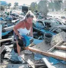  ?? RUSS BYNUM THE ASSOCIATED PRESS ?? Dena Frost salvages an unbroken clay pot from the wreckage of her pottery business in Mexico Beach, Fla.