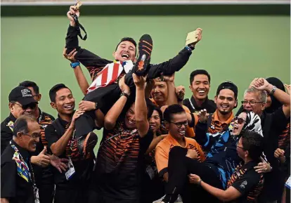  ??  ?? Well done: Mohd Soufi Rusli being lifted up by teammates after winning the gold in the men’s singles final at the National Lawn Bowls Centre in Bukit Kiara yesterday.