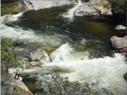  ?? RECORDER PHOTO BY CHIEKO HARA ?? Above: Rescue crews search raging white water on the upper Tule River on May 3. Right: The Tule River has subsided since May and the river is now open to the public.