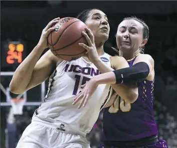  ?? Jessica Hill/Associated Press ?? Albany's Mackenzie Trpcic, right, fouls Connecticu­t's Gabby Williams in the first half of a women’s first-round game Saturday in Storrs, Conn.