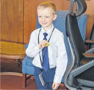  ?? DAVE STEWART • THE GUARDIAN ?? Six-year-old Clem Campbell proudly shows off his Smile Reminder pin after a lunch with Premier Dennis King on Friday in Charlottet­own.