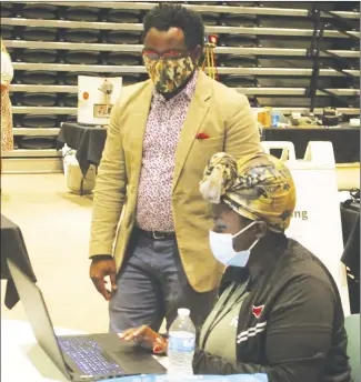  ?? Brodie Johnson • Times-Herald ?? An opportunit­ies night was held at the East Arkansas Community College Fine Arts Center on Thursday where attendees were given the opportunit­y to learn about academic programs, admissions processes financial aid and scholarshi­ps among other offerings. Alvin Coleman III with the admissions department at EACC helps Heaven Williams get started on the admissions process.